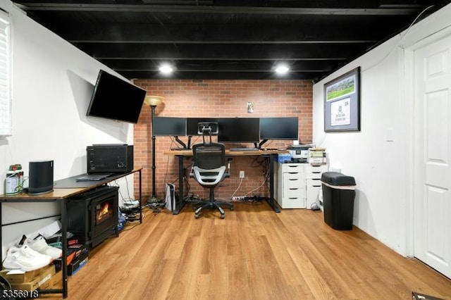 office featuring wood finished floors and brick wall