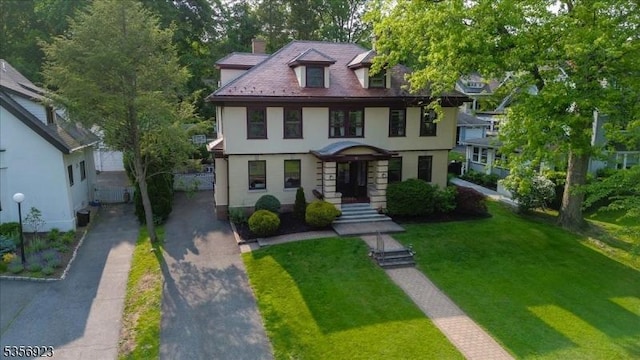12 Harrison Ave, Montclair Twp, NJ 07042 - view of front of home with a chimney, a front yard, asphalt driveway, and stucco siding