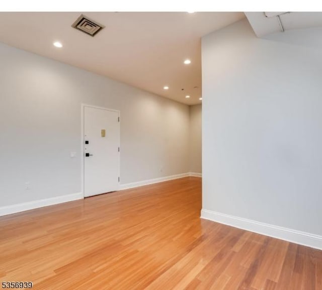 spare room with recessed lighting, light wood finished floors, and baseboards