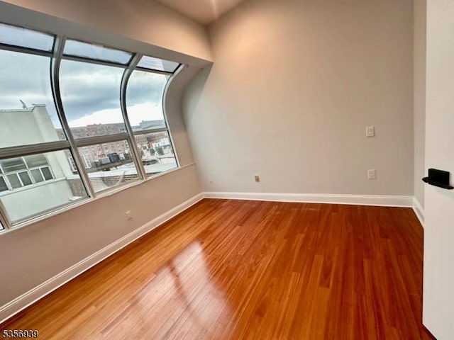 unfurnished room featuring baseboards and wood finished floors