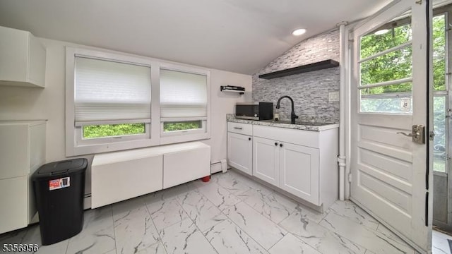 29 Oldham Rd, Wayne Twp, NJ 07470 - kitchen with stainless steel microwave, vaulted ceiling, white cabinetry, light stone counters, and healthy amount of natural light