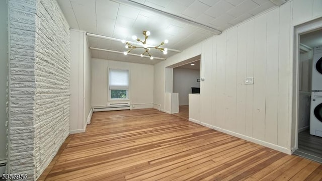 29 Oldham Rd, Wayne Twp, NJ 07470 - unfurnished dining area featuring estacked washer and dryer, a chandelier, light wood finished floors, and baseboards