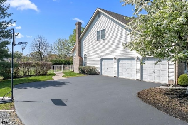 38 Southfield Dr, Montgomery Twp, NJ 08502 - view of side of property featuring asphalt driveway, fence, a chimney, and a garage