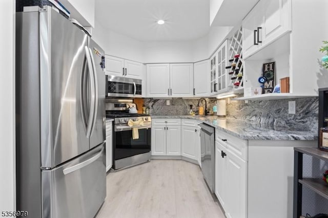 21 Stepping Rdg, North Caldwell Boro, NJ 07006 - kitchen with appliances with stainless steel finishes, a sink, light wood-type flooring, white cabinetry, and glass insert cabinets