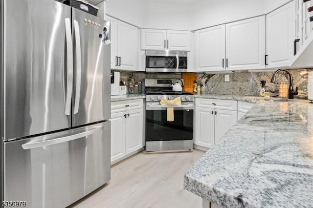 21 Stepping Rdg, North Caldwell Boro, NJ 07006 - kitchen featuring appliances with stainless steel finishes, a sink, light stone counters, and white cabinets