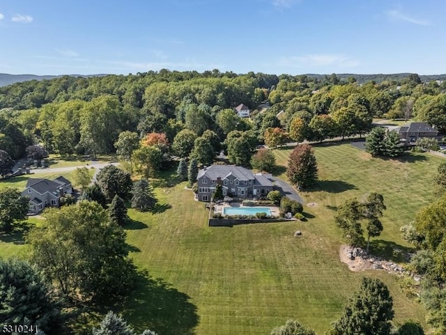 aerial view of property's location with a pool area and a forest