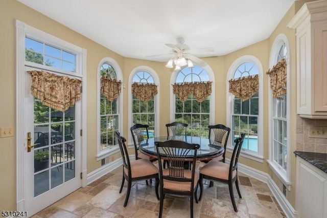 sunroom with stone tile floors, healthy amount of natural light, and baseboards