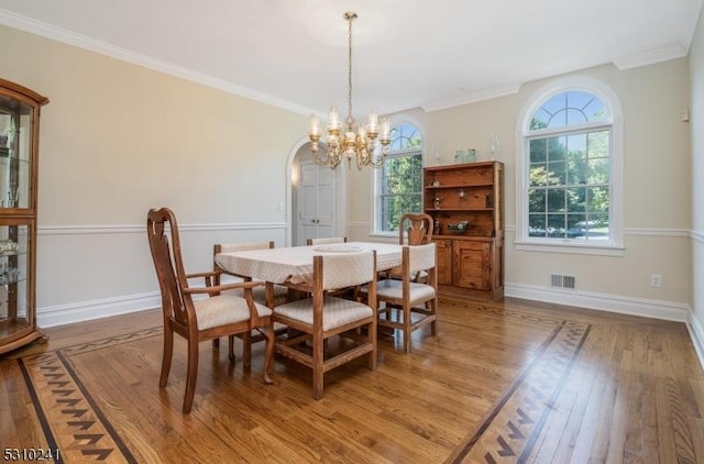 dining area featuring a chandelier, light wood-style floors, baseboards, and ornamental molding