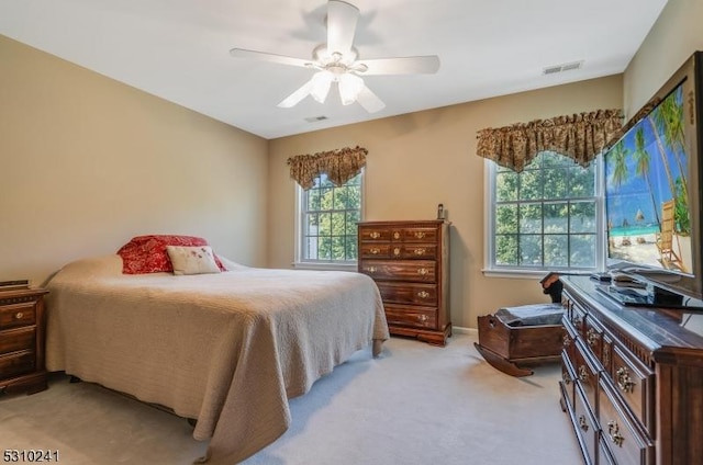 bedroom with light carpet, ceiling fan, and baseboards