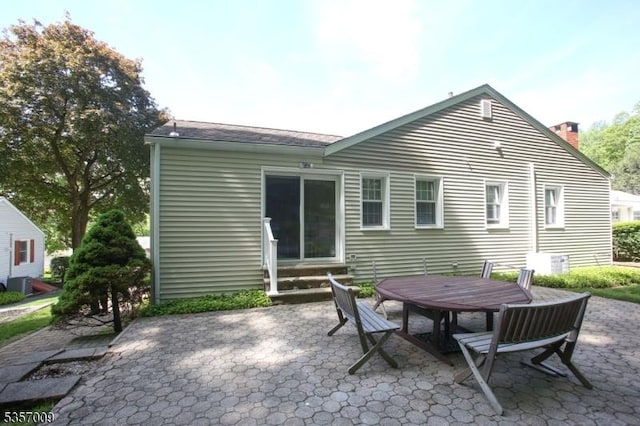 45 Linwood Ave, Dover Town, NJ 07801 - rear view of house featuring entry steps, a patio area, a chimney, and cooling unit