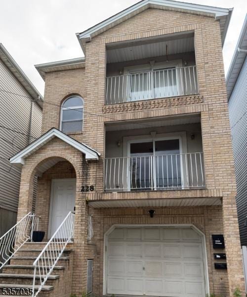 view of front facade featuring a balcony, brick siding, and an attached garage