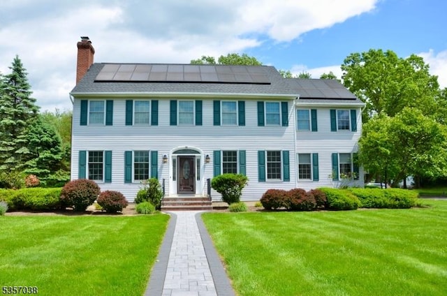 16 Dorset Ln, Andover Twp, NJ 07848 - colonial home with a chimney, a front lawn, and roof mounted solar panels