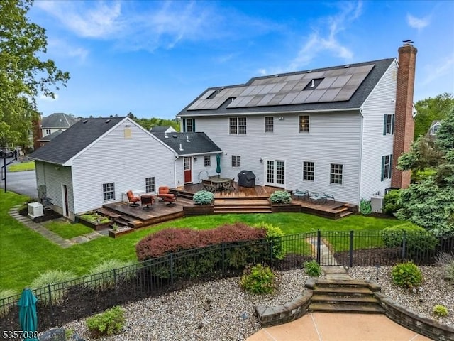 16 Dorset Ln, Andover Twp, NJ 07848 - back of house featuring a wooden deck, solar panels, and a chimney
