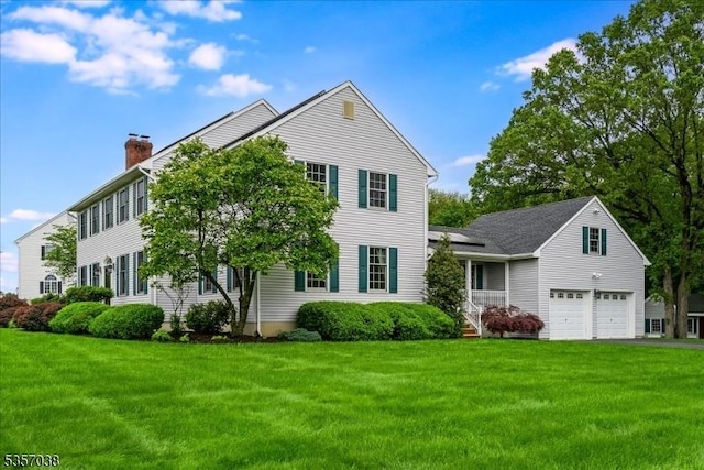 16 Dorset Ln, Andover Twp, NJ 07848 - view of front of home featuring a front yard, a chimney, roof mounted solar panels, and driveway