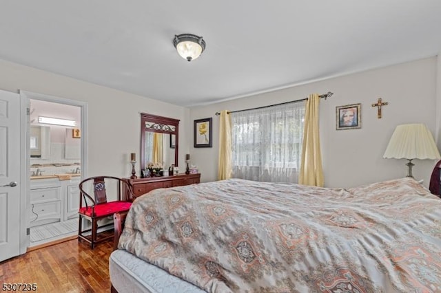 bedroom featuring wood finished floors and ensuite bathroom