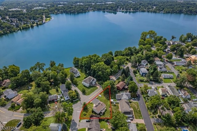 aerial perspective of suburban area with property boundaries highlighted and a nearby body of water