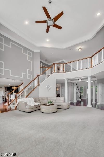 4 Frey Rd, Hillsborough Twp, NJ 08844 - carpeted living area with stairway, decorative columns, a ceiling fan, a high ceiling, and recessed lighting