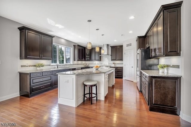 4 Frey Rd, Hillsborough Twp, NJ 08844 - kitchen featuring a kitchen island, freestanding refrigerator, dark brown cabinetry, a breakfast bar, and wood finished floors