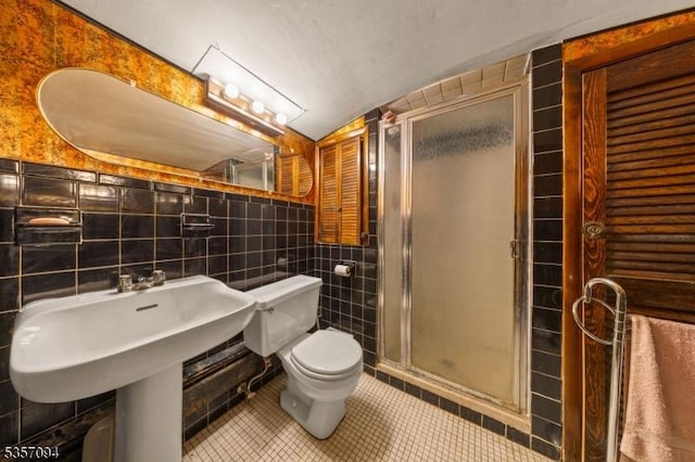 full bathroom with tile walls, a shower stall, tile patterned flooring, and toilet