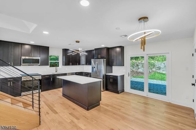 162 Lakeside Blvd, Hopatcong Boro, NJ 07843 - kitchen featuring appliances with stainless steel finishes, light countertops, light wood-type flooring, decorative light fixtures, and a kitchen island