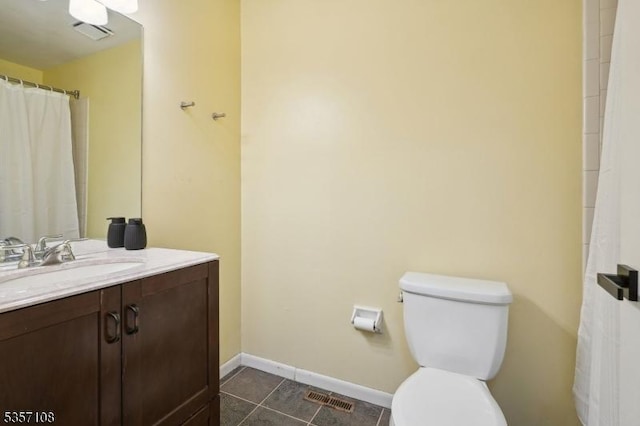 bathroom with baseboards, vanity, toilet, and tile patterned flooring