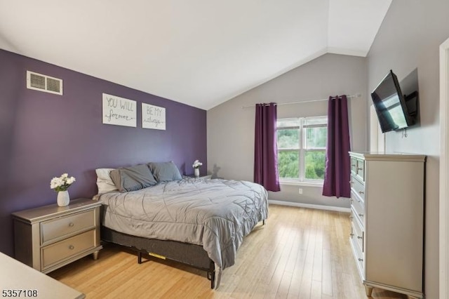 bedroom featuring light wood-style flooring and lofted ceiling