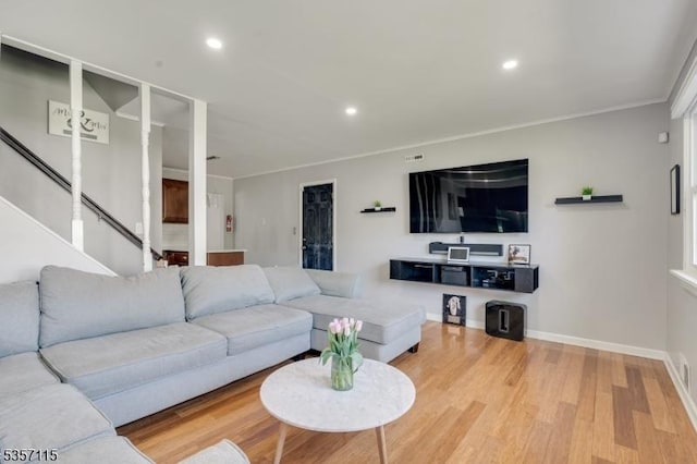 living area featuring wood finished floors, recessed lighting, baseboards, ornamental molding, and stairs