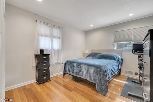bedroom featuring wood finished floors, recessed lighting, and baseboards