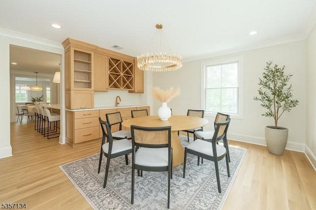 157 Meyersville Rd, Chatham Twp, NJ 07928 - dining area featuring light wood-type flooring, baseboards, bar with sink, recessed lighting, and crown molding
