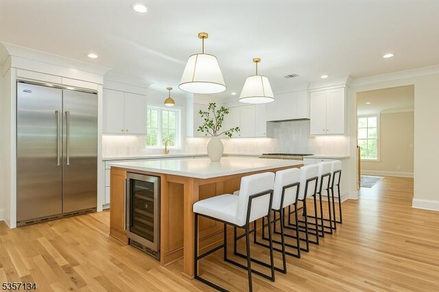 157 Meyersville Rd, Chatham Twp, NJ 07928 - kitchen with stainless steel built in refrigerator, wine cooler, a large island, backsplash, and recessed lighting