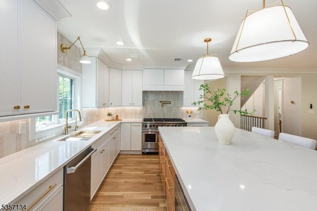 157 Meyersville Rd, Chatham Twp, NJ 07928 - kitchen featuring stainless steel appliances, a sink, light wood-style flooring, tasteful backsplash, and white cabinetry