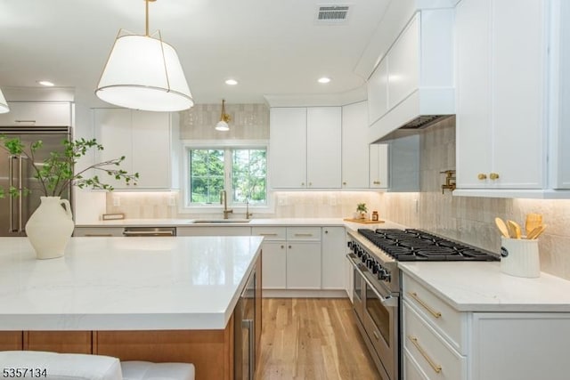 157 Meyersville Rd, Chatham Twp, NJ 07928 - kitchen with stainless steel stove, a sink, light wood-style flooring, backsplash, and white cabinets