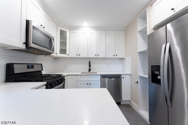 kitchen with stainless steel appliances, light countertops, a sink, and tasteful backsplash