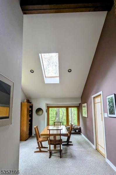 15 Pschorn Ln, Hillsborough Twp, NJ 08844 - carpeted dining area with high vaulted ceiling, a skylight, and baseboards