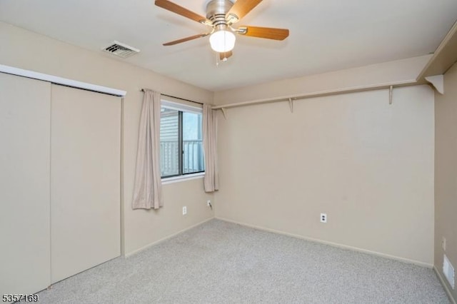 unfurnished bedroom featuring carpet, baseboards, a ceiling fan, and a closet