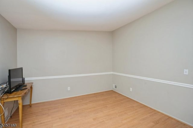 spare room featuring light wood finished floors and baseboards