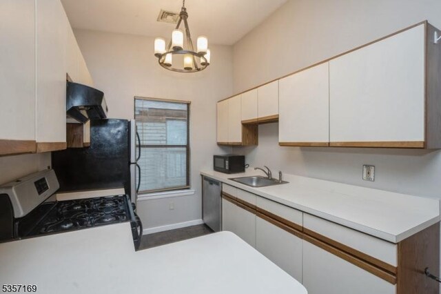 kitchen featuring a sink, ventilation hood, appliances with stainless steel finishes, white cabinetry, and a chandelier