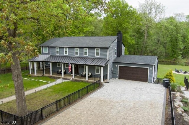 276 River Dr, River Vale Twp, NJ 07675 - view of front facade with a porch, a standing seam roof, an attached garage, a chimney, and decorative driveway