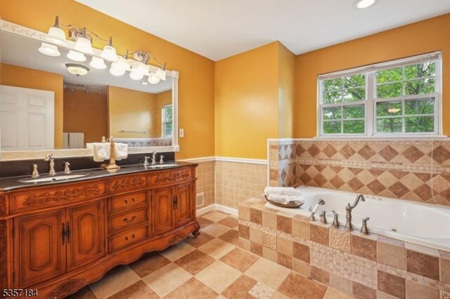 47 Nostrand Rd, Hillsborough Twp, NJ 08844 - bathroom featuring a whirlpool tub, double vanity, a wainscoted wall, and tile walls