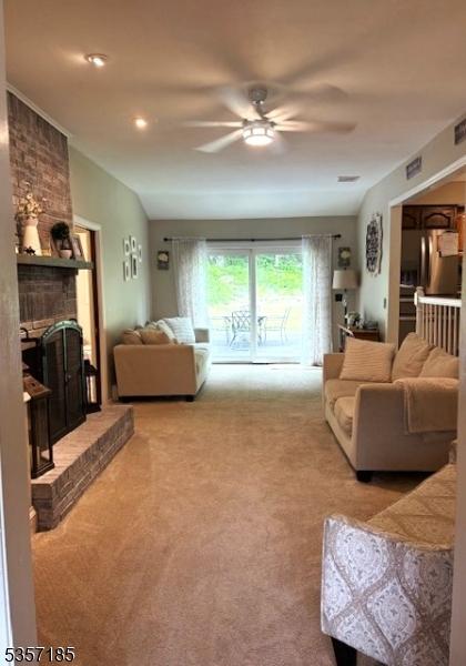 32 Northgate, Wanaque Boro, NJ 07465 - living room featuring carpet, a ceiling fan, and a fireplace
