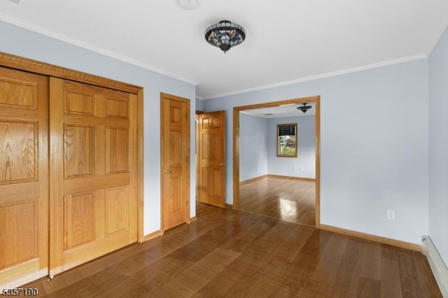 hall with dark wood-style flooring, baseboards, and crown molding