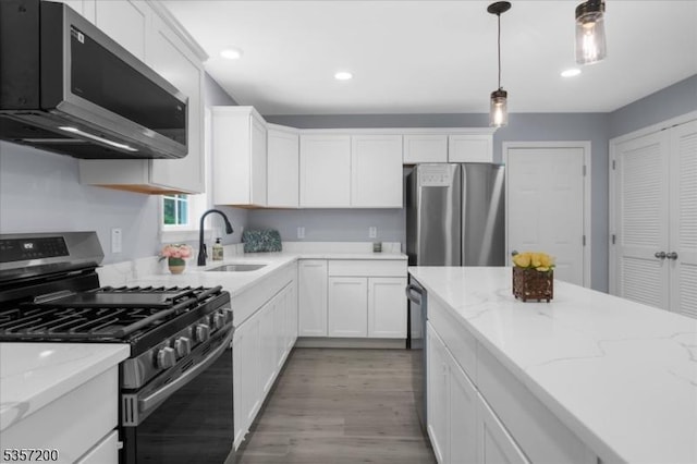 56 Anthony Rd, Lebanon Twp, NJ 08826 - kitchen with appliances with stainless steel finishes, a sink, light wood finished floors, white cabinetry, and pendant lighting