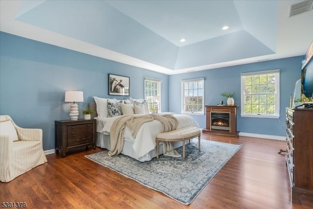 156 Fox Chase Rd, Chester Twp, NJ 07930 - bedroom featuring a raised ceiling, dark wood-style flooring, baseboards, a warm lit fireplace, and recessed lighting