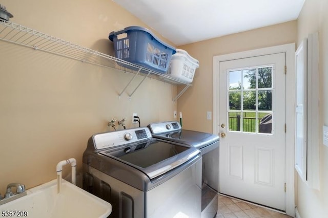 laundry room with washing machine and clothes dryer and light tile patterned floors