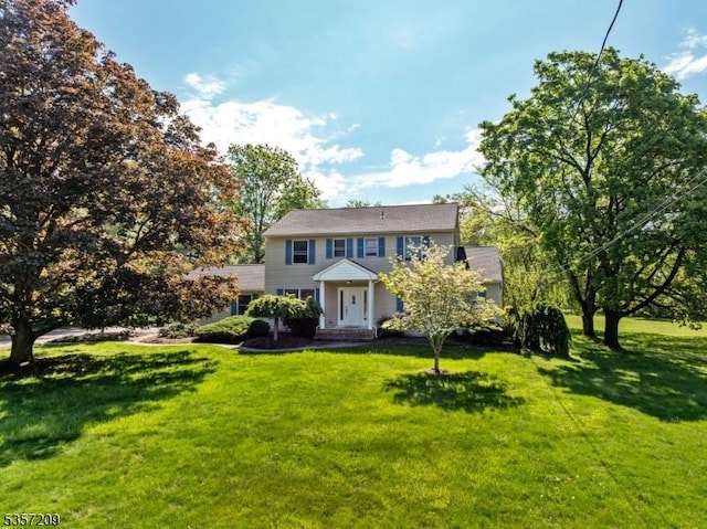 colonial home featuring a front lawn