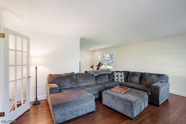living room with wood finished floors, crown molding, and baseboards