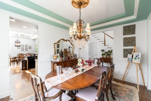 dining area featuring a chandelier, wood finished floors, and stairway