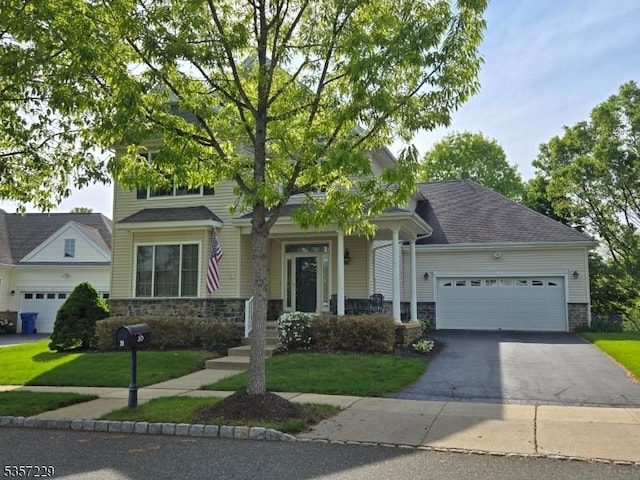 view of front of house featuring stone siding, driveway, an attached garage, and a front lawn