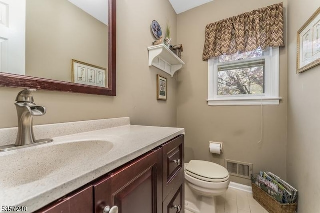 half bath with toilet, vanity, and baseboards
