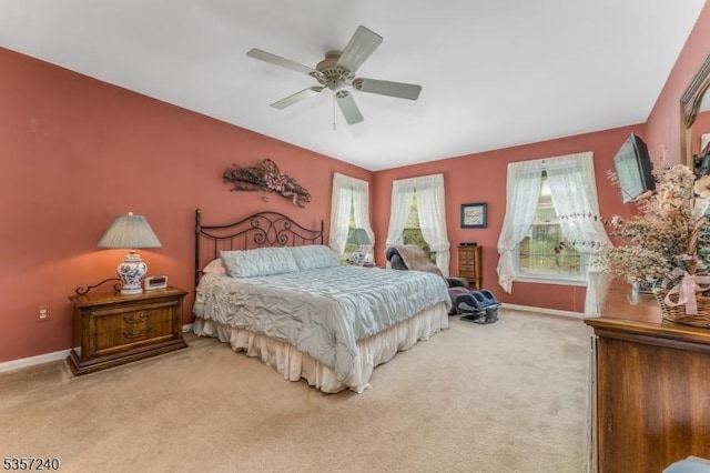 bedroom with light colored carpet, baseboards, and ceiling fan